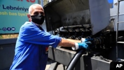 A worker pumps gasoline from a fuel truck to supply a gas station in Beirut, Lebanon, June 25, 2021.