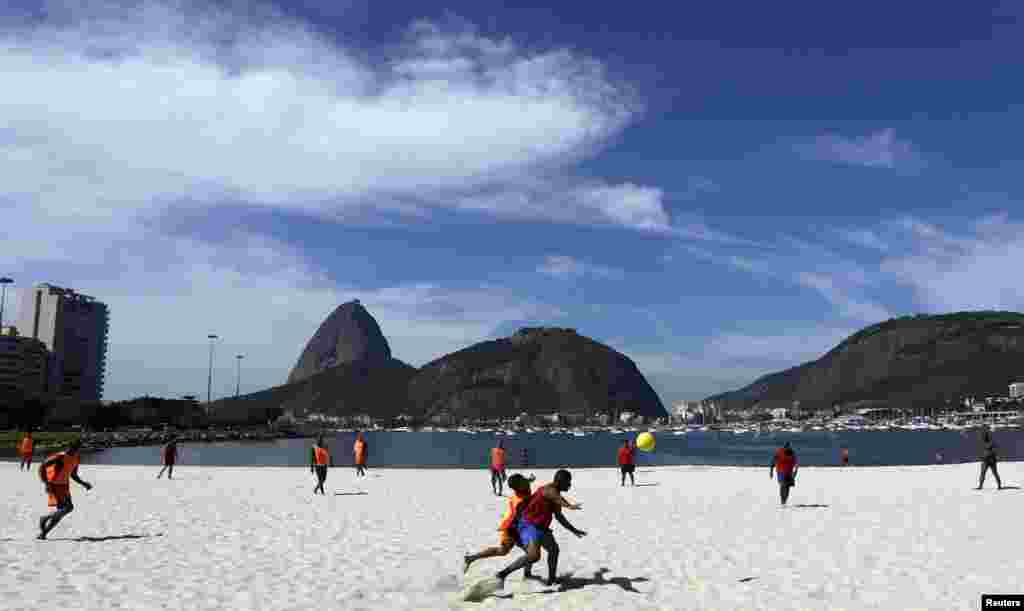 Um grupo de amigos joga na praia do Botafogo, no Rio de Janeiro. O povo brasileiro vive freneticamente o futebol. A cidade do Rio de Janeiro é uma das anfitriãs da competição que se realiza de 12 de Junho a 13 de Julho. Maio 4, 2014