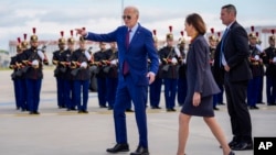 El presidente Joe Biden habla con la embajadora de Estados Unidos en Francia, Denise Campbell Bauer, segunda desde la derecha, junto a una guardia de honor francesa después de llegar al aeropuerto de Orly, al sur de París, el miércoles 5 de junio de 2024.