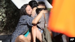 Parents of victims embrace each other near the scene of a truck attack in Nice, France, July 15, 2016.