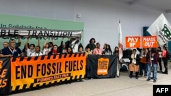 Climate activists stage a protest inside the COP29 venue to demand a phase out of fossil fuels during the United Nations Climate Change Conference in Baku on Nov. 15, 2024.