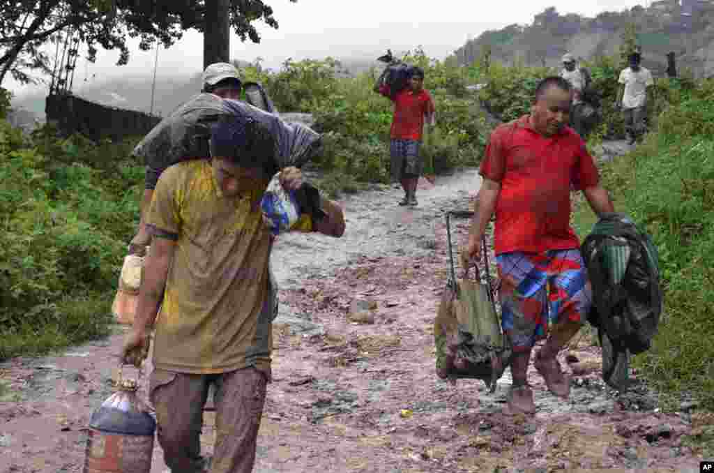 Warga membawa barang-barang milik mereka setelah tanah longsor yang dipicu hujan besar akibat Badai Tropis Manuel menghancurkan rumah mereka di Chilpancingo, negara bagian Guerrero, Meksiko (16/9). (AP/Alejandrino Gonzalez)