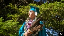 
Dayne Hudson, a member of the Paiute Indian Tribe of Utah, walks with his eagle feather fan during the Canyon View High School graduation on May 22, 2022 in Cedar City, Utah. AP/Rick Bowmer
