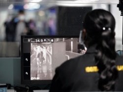 A health official watches travelers on a thermographic monitor at the Kuala Lumpur International Airport in Sepang, Malaysia, Jan. 21, 2020.