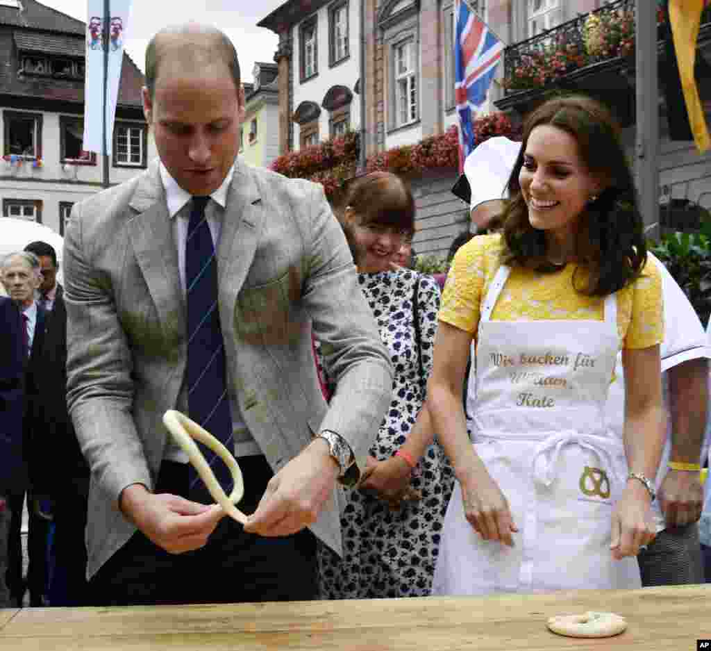 Britain's Prince William and his wife Kate, the Duchess of Cambridge, form pastry to pretzels as they visit the market in the historic center of the southern German town of Heidelberg.