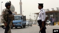 Binh sĩ và cảnh sát Iraq canh gác trên một con đường ở trung tâm thủ đô Baghdad. Tháng chay Ramadan là thời gian quân nổi dậy thường gia tăng các cuộc tấn công