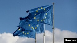 FILE — The EU's flags fly outside the EU Commission headquarters in Brussels, Belgium Sept 19, 2019.