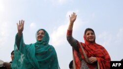 Kulsoom Nawaz (kiri), istri, dan Maryam Nawaz (kanan), anak perempuan mantan perdana menteri Pakistan Nawaz Sharif, melambaikan tangan ke arah para pendukung dalam sebuah kampanye di Lahore, Pakistan, 4 Mei 2013. 