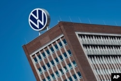 Logo Volkswagen terlihat di atas gedung markas VW di Wolfsburg, Jerman. (Foto: via AP)