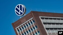 FILE - In this Monday, April 27, 2020. file photo, The Volkswagen logo stand on the top of a VW headquarters building in Wolfsburg, Germany. Volkswagen is gradually launch the production at important plants after the corona lockdown. (Swen Pfoertner/dpa…