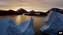 An aerial view of large Icebergs floating as the sun rises near Kulusuk, Greenland, early Aug. 16, 2019. 