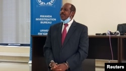 FILE - Paul Rusesabagina, hailed as a hero in a Hollywood movie about Rwanda's 1994 genocide, is handcuffed in front of reporters at Rwanda's Investigation Bureau, in Kigali, Aug. 31, 2020. Freed recently from prison there, he arrived in the U.S. on March 29, 2023.