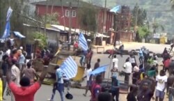 FILE - A still image taken from a video shot on October 1, 2017, shows protesters waving Ambazonian flags in front of road block in the English-speaking city of Bamenda, Cameroon.