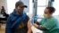Brian Kennedy, an elementary school physical education teacher, gets a COVID-19 vaccination during a mass vaccination of 1,000 employees of Denver Public Schools Feb. 13, 2021, in Denver, Colo.