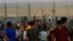 Protesters chant while try to climb the fence of the Gaza Strip's border with Israel, east of Gaza City, Aug. 21, 2021.