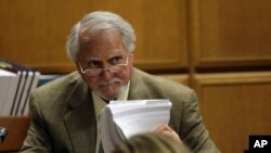 FILE - Best-selling author Clive Cussler looks over material while testifying in Los Angeles Superior Court, Feb. 13, 2007. 