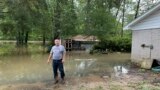 Miguel Flores se encuentra en su patio trasero inundado afuera de su casa en el vecindario de Kingwood, en el noreste de Houston, Texas, EEUU, el sábado 4 de mayo de 2024. (Foto AP/Juan Lozano)