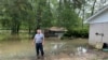 Местный житель на затопленном дворе возле своего дома в северо-восточном районе Хьюстона, 4 мая 2024 года. 