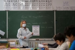 A teacher gives a lesson at the Cour de Lorraine elementary school in Mulhouse, eastern France, on its reopening day for pupils, May 18, 2020, as France eases lockdown measures taken to curb the spread of COVID-19.