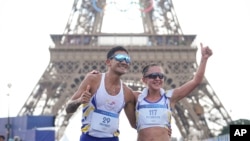 Los ecuatorianos Brian Daniel Pintado y Glenda Morejón festejan luego de cruzar la meta y obtener la plata en el maratón de relevo de marcha de los Juegos Olímpicos, el miércoles 7 de agosto de 2024, en París.