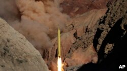 In this photo obtained from the Iranian Fars News Agency, a Qadr H long-range ballistic surface-to-surface missile is fired by Iran's Revolutionary Guard, during a maneuver, in an undisclosed location in Iran, Wednesday, March 9, 2016.