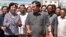 Cambodian Prime Minister Hun Sen, center, cuts the ribbon with Chinese Ambassador to Cambodia Bu Jianguo, left, during the inauguration ceremony of a friendship bridge between Cambodia and China in Takhmao, Kandal provincial town, south of Phnom Penh, Cambodia, Monday, Aug. 3, 2015. The bridge across the Tonle Bassac River opened to the public on Monday. (AP Photo/Heng Sinith)