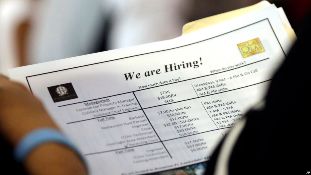 FILE - A job applicant looks at job listings for the Riverside Hotel at a job fair hosted by Job News South Florida, in Sunrise, Fla.