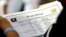FILE - A job applicant looks at job listings for the Riverside Hotel at a job fair hosted by Job News South Florida, in Sunrise, Fla.