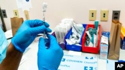 A pharmacist prepares a syringe with the Pfizer-BioNTech COVID-19 vaccine at a COVID-19 vaccination site at NYC Health + Hospitals Metropolitan, in New York, Feb. 18, 2021.