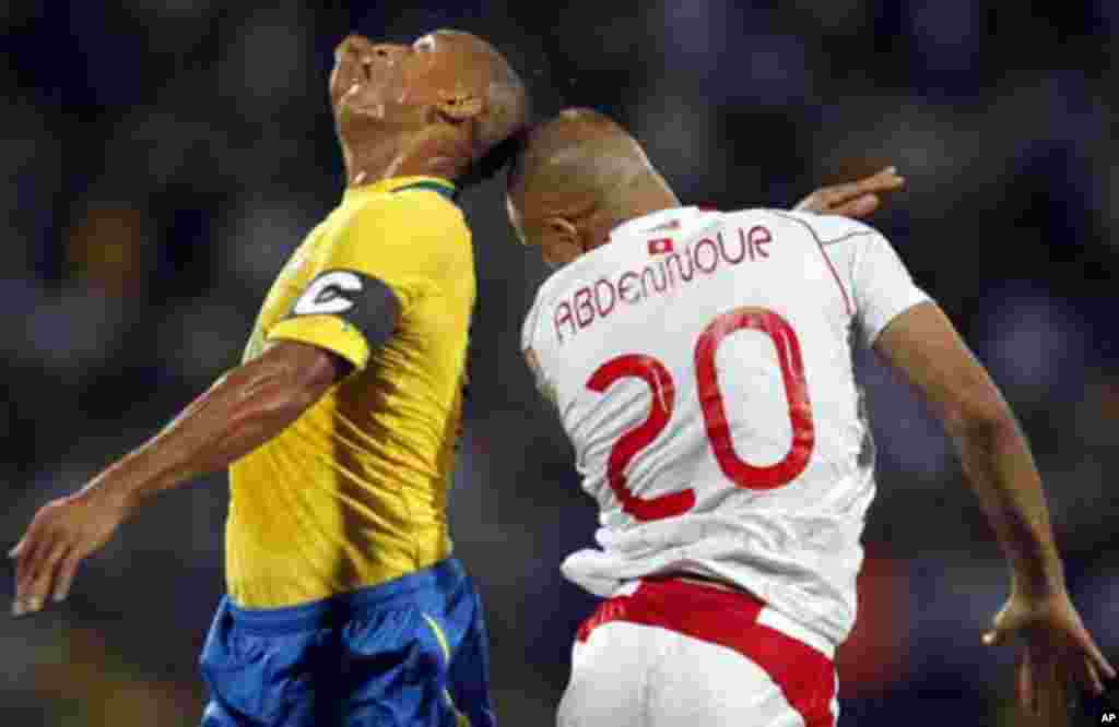 Gabon's Daniel Cousin (L) challenges Aymen Abdennour of Tunisia during their African Cup of Nations Group C soccer match at Franceville stadium in Gabon January 31, 2012.
