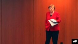 German Chancellor Angela Merkel waits for the beginning of a press conference in Berlin, Germany, May 6, 2020 after an online meeting of Merkel and the German state governors on the loosening of the restictions to reduce the spread of the new coronavirus.