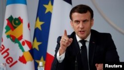 Le président français Emmanuel Macron fait un geste alors qu'il prononce un discours après une réunion par vidéoconférence avec les dirigeants des pays ouest-africains du G-5 Sahel, à Paris, le 16 février 2021.