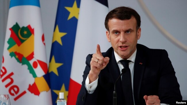 FILE - French President Emmanuel Macron gestures as he delivers a speech after a meeting via video-conference with leaders of West African G-5 Sahel nations, in Paris, France, Feb. 16, 2021.