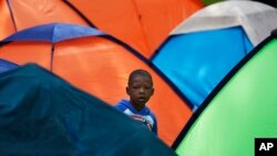 Un niño observa desde un campamento en la plaza de Giordano Bruno, en Ciudad de México, el 18 de mayo de 2023. El pequeño forma parte de un grupo de migrantes que aspira a llegar a la frontera con EEUU.