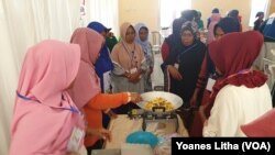 Para perempuan mempraktikkan cara membuat camilan kacang sembunyi dalam kegiatan pelatihan keterampilan di Petobo, Kota Palu, Sulawesi Tengah, Rabu, 18 September 2019. (Foto: Yoanes Litha/VOA)