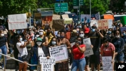 Les manifestants se rassemblent devant la Cour pénale du comté de Queens le lundi 8 juin 2020, dans le quartier de Queens à New York. 