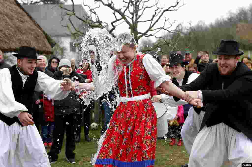 Men throw water on a woman as part of traditional Easter celebrations in Szenna, Hungary.
