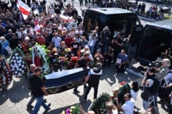 Men carry a coffin with the body of Alexander Taraikovsky, a 34-year-old demonstrator who died Aug. 10, 2020, amid clashes while protesting election results, during his funeral ceremony in central Minsk, Belarus, Aug. 15, 2020.