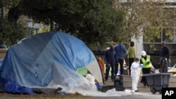 Oakland public works employees survey and clean up Frank Ogawa plaza Monday, Nov. 14, 2011 in Oakland, Calif. The Occupy encampment was evicted from the plaza early this morning.