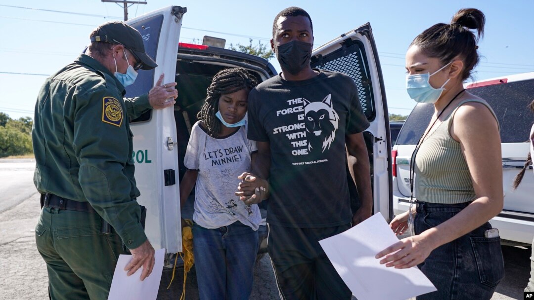 Un agente dela Patrulla Fronteriza de EE. UU. entrega una pareja de migrantes a un miembro de una organización humanitaria, después de su liberación, el viernes 24 de septiembre de 2021, en Del Rio, Texas.