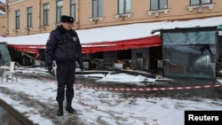 A police officer stands guard at the scene of the cafe explosion in which Russian military blogger Vladlen Tatarsky, (real name Maxim Fomin) was killed the day before in Saint Petersburg, Russia April 3, 2023. 