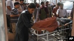 Afganos atienden a un hombre herido por la explosión de una bomba caminera en una carretera entre Herat, en el este del país, y Kandahar, en el sur, en Herat, Afganistán, el 31 de julio de 2019. 