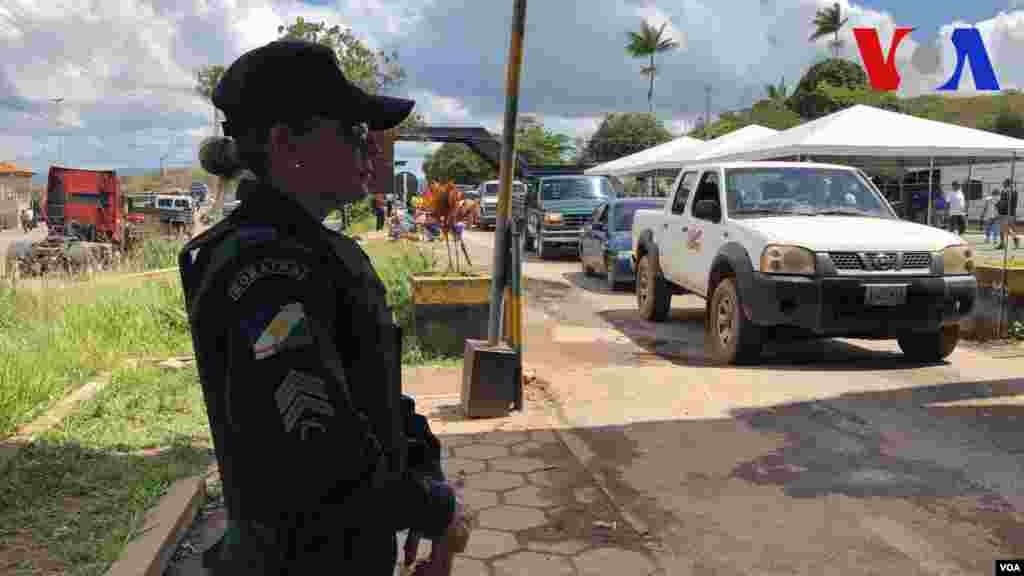Una mujer policía vigila en el punto de control de la frontera en Pacaraima, Brasil. Foto: Celia Mendoza - VOA