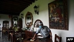 Un hombre limpia una mesa en el área de restaurante de un hotel en Antigua Guatemala, departamento de Sacatepéquez, a 45 km al sureste de la ciudad de Guatemala el 6 de septiembre de 2020.