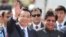 Chinese Premier Li Keqiang waves as he is received by Indian junior minister for external affairs, E. Ahamed, right, after he arrived in New Delhi, India, May 19, 2013. 
