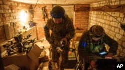 A Ukrainian soldier of the ACHILLES battalion of the 92nd brigade carries a suicide FPV drone to the take-off position before its launch over Russian positions in Ukraine's Kharkiv region, May 13, 2024.