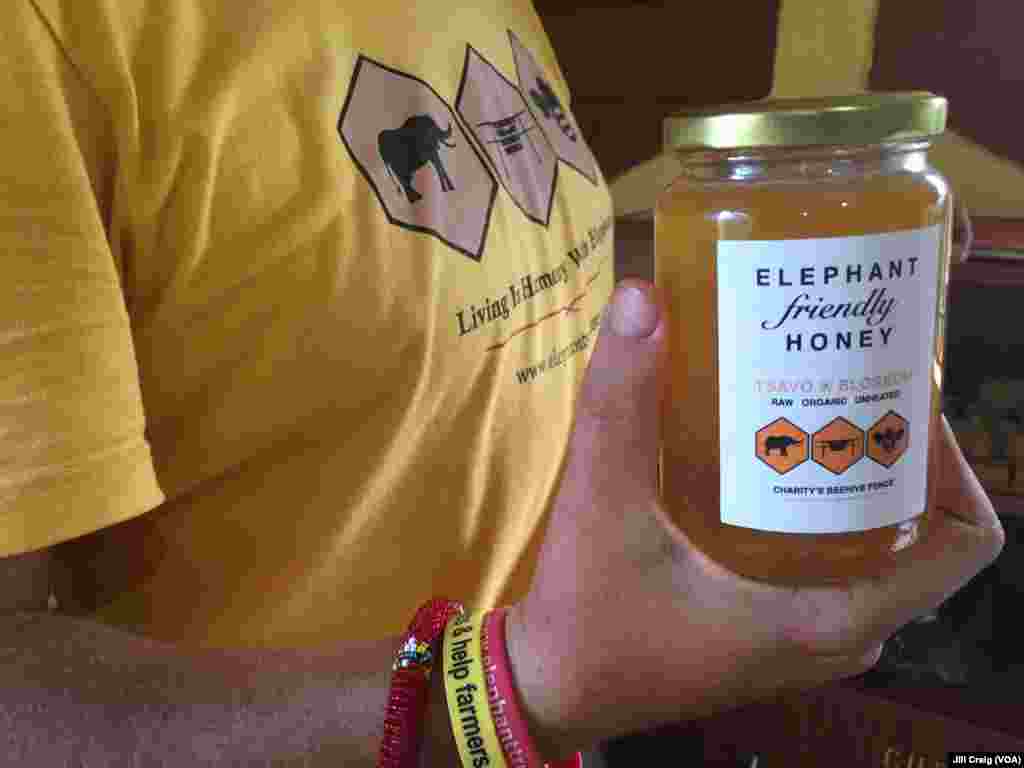 Elephants and Bees Project research center coordinator Matthew Rudolph shows a jar of honey that came from beehives at Charity Mwangome’s farm, in Taita-Taveta area, Kenya, April 19, 2016.