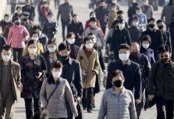 FILE - People wearing protective face masks commute amid concerns over the new coronavirus disease (COVID-19) in Pyongyang, North Korea, March 30, 2020, in this photo released by Kyodo.