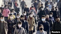 People wearing protective face masks commute amid concerns over the new coronavirus disease (COVID-19) in Pyongyang, North Korea, March 30, 2020, in this photo released by Kyodo.