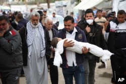 Mohsen Muammar carries the body of his 3-year-old son Muhammad, who was killed in the Israeli bombardment of the Gaza Strip, to his family house to bury him in Rafah, on March 29, 2024.